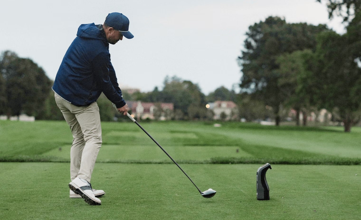 Golfer swinging club on green golf course