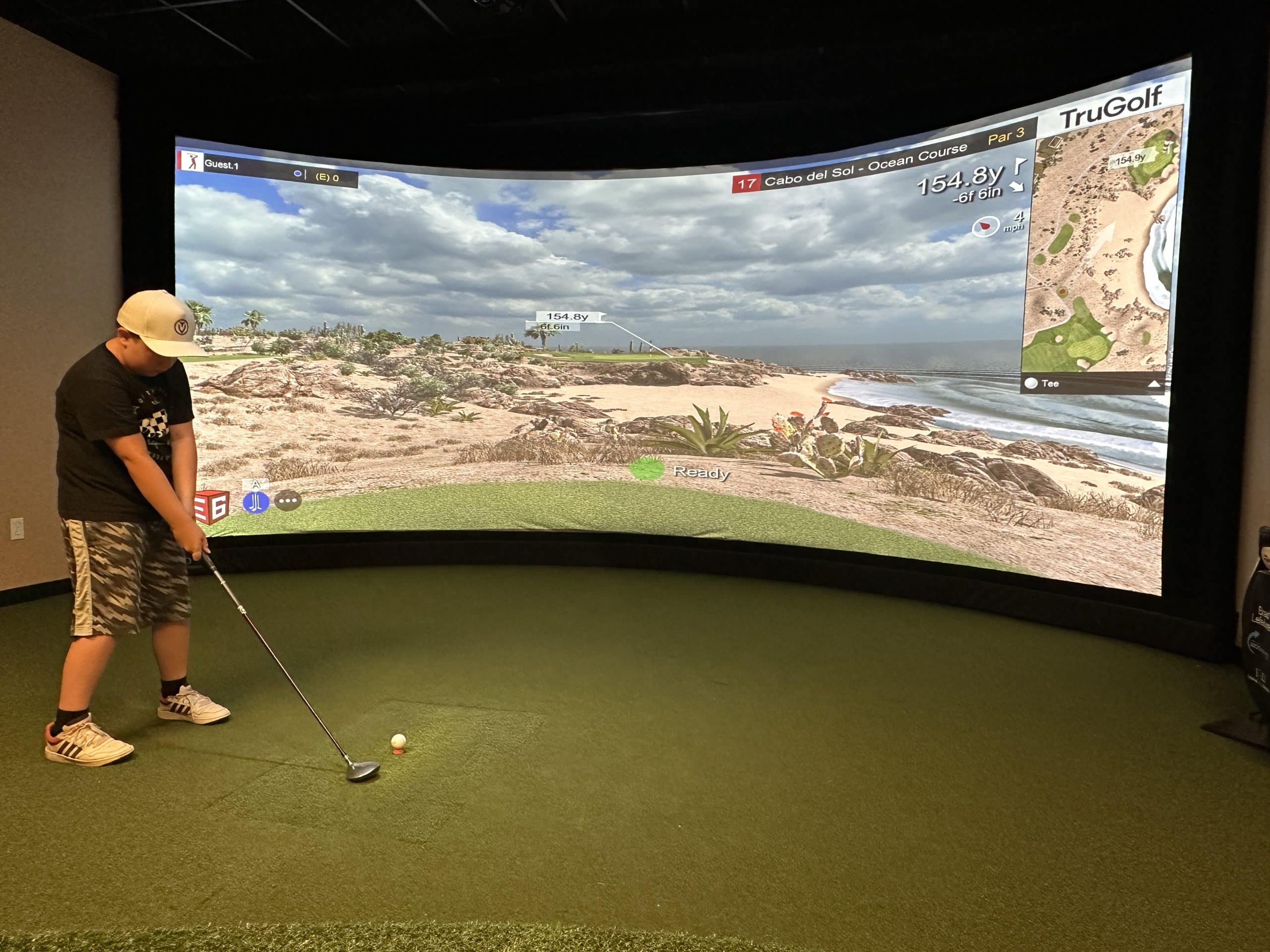 Person playing indoor golf simulator game