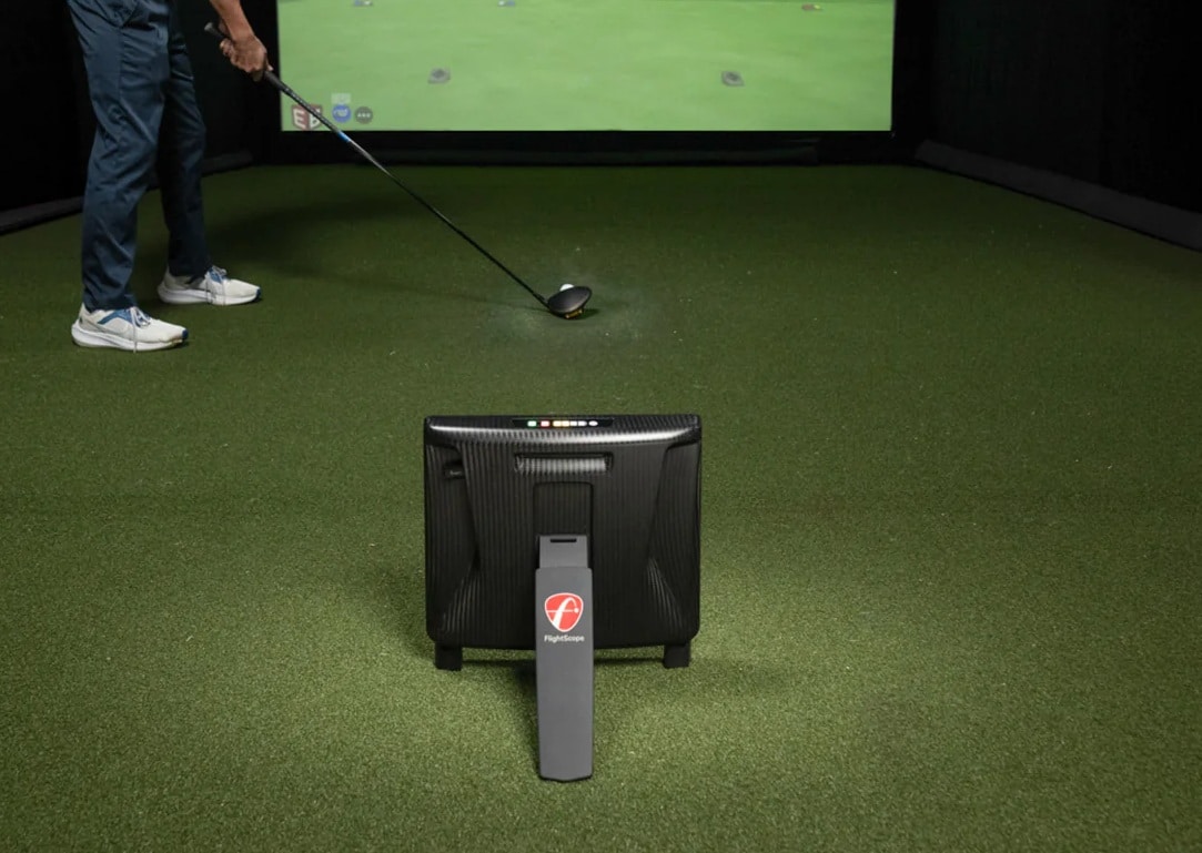 Golfer using indoor simulator with launch monitor