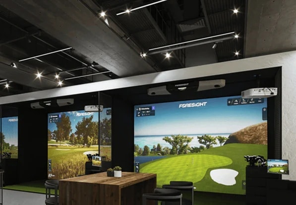 Indoor golf simulator setup with digital screens