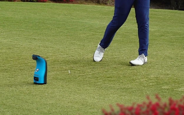 Golfer practicing with blue swing analyzer device