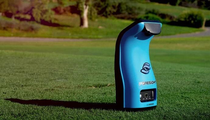 Blue golf launch monitor on grass course