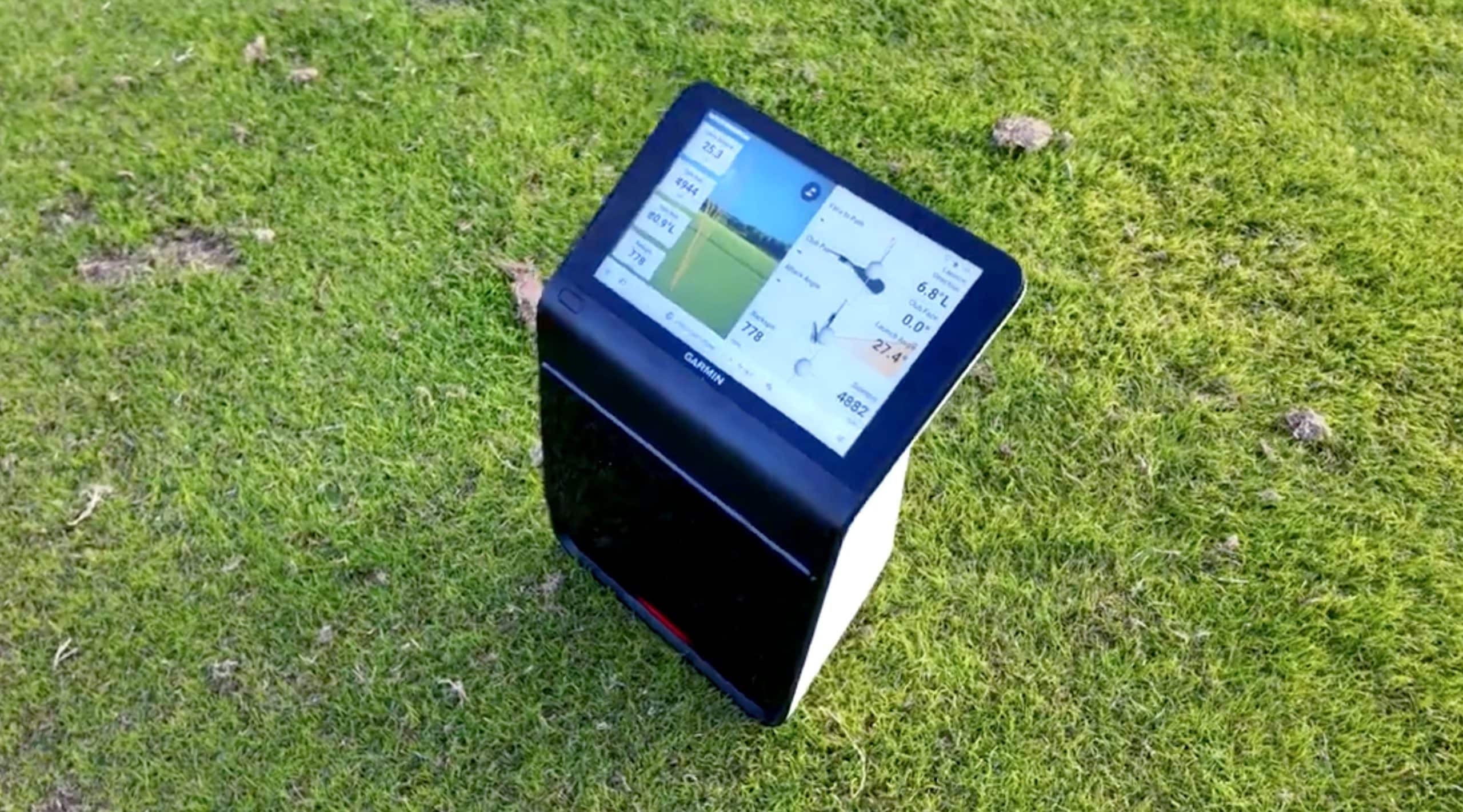Golf launch monitor on grass displaying shot data