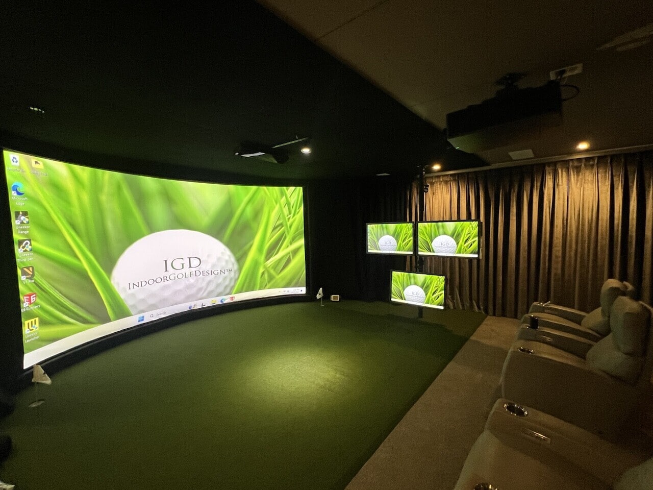 Indoor golf simulator room with curved screen