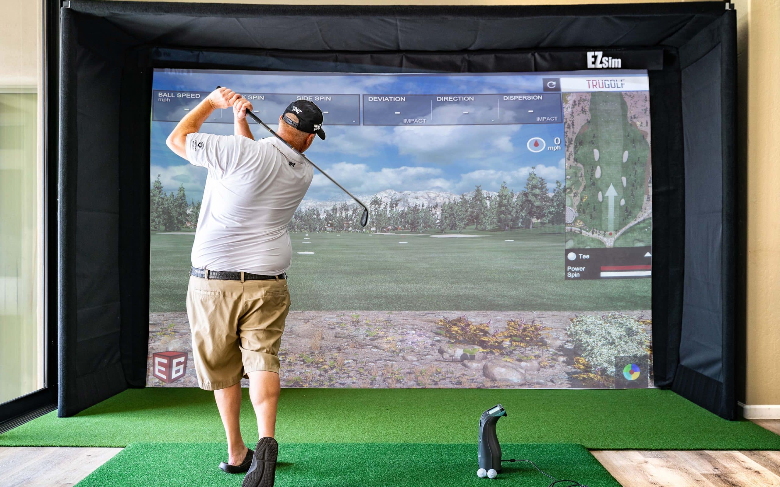 Man playing golf on indoor simulator