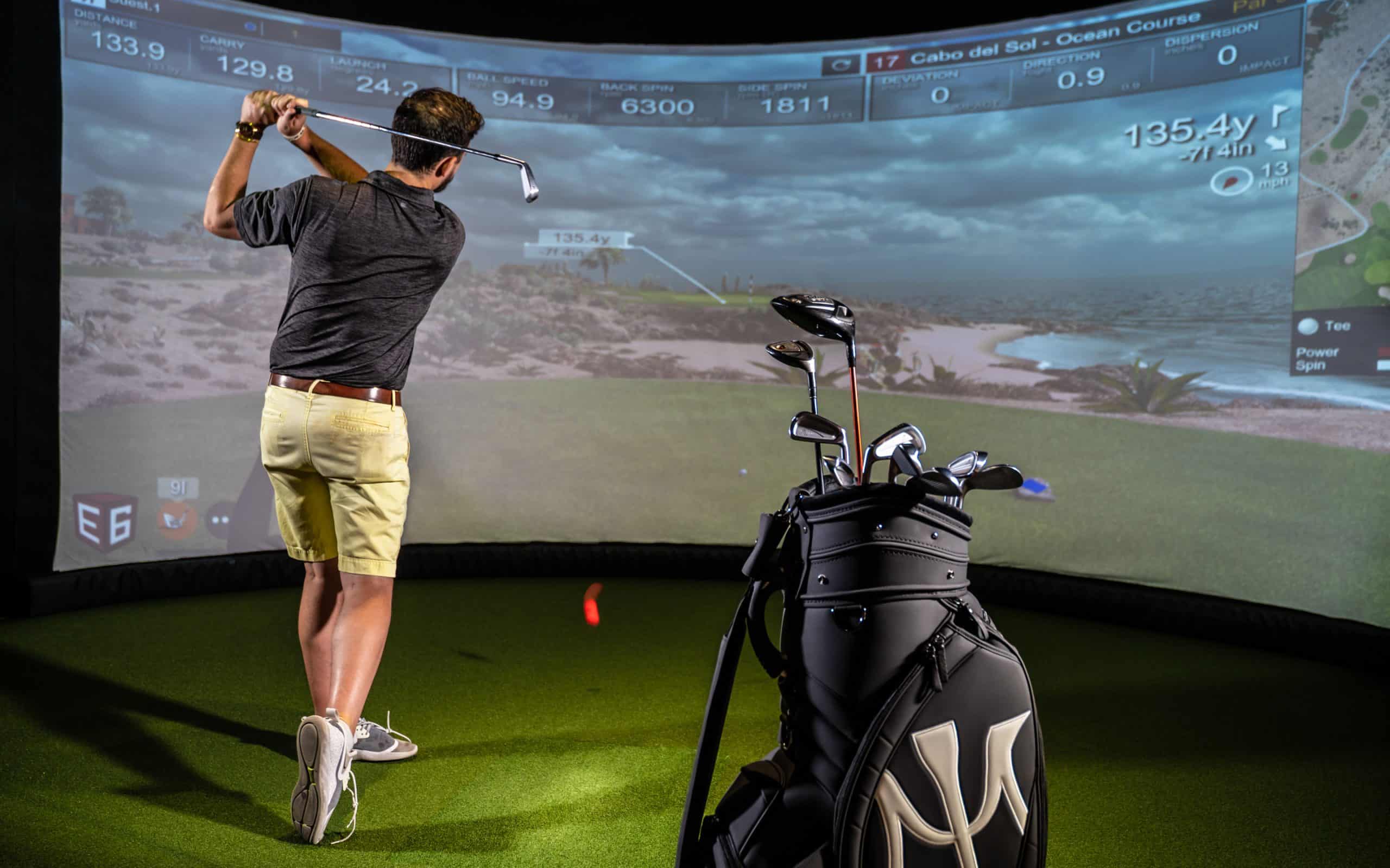Man playing golf on indoor simulator