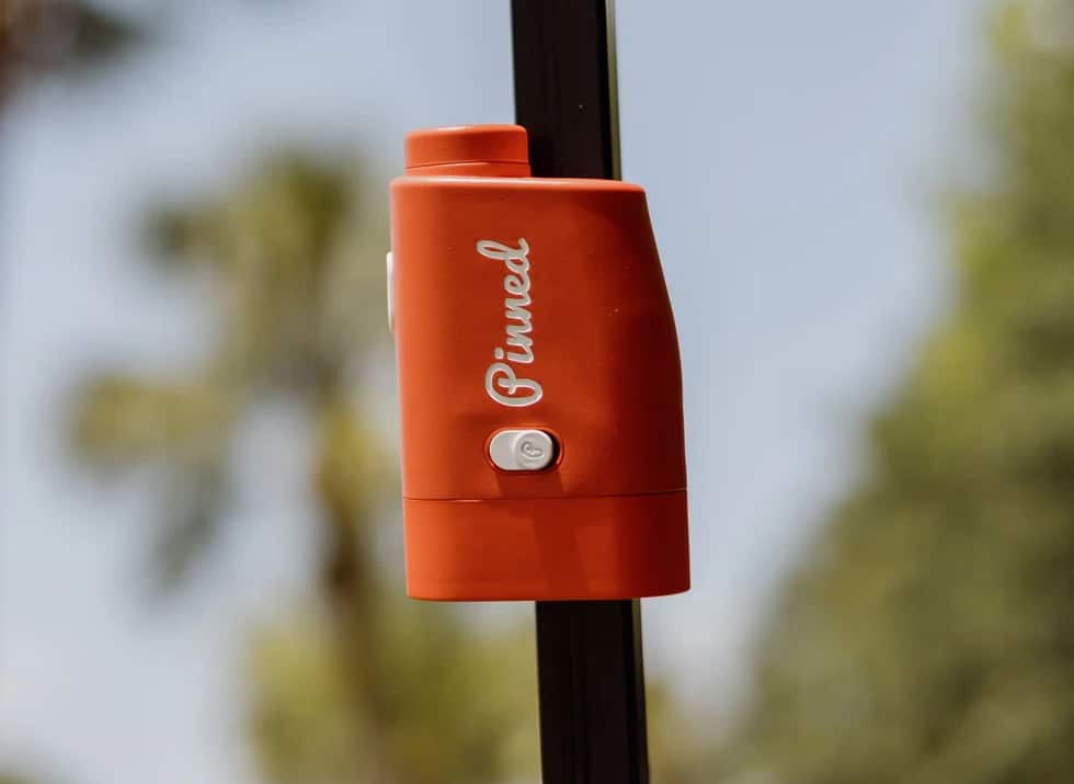 Orange Pinned golf rangefinder on a pole outdoors