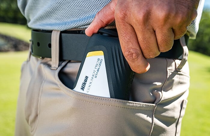 Golfer holding Nikon rangefinder in pocket