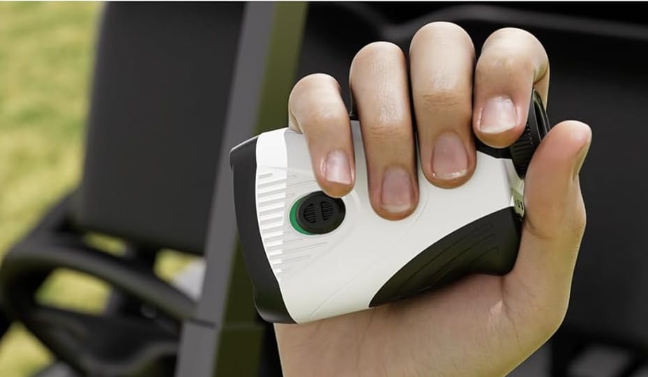 Hand holding digital golf rangefinder device outdoors