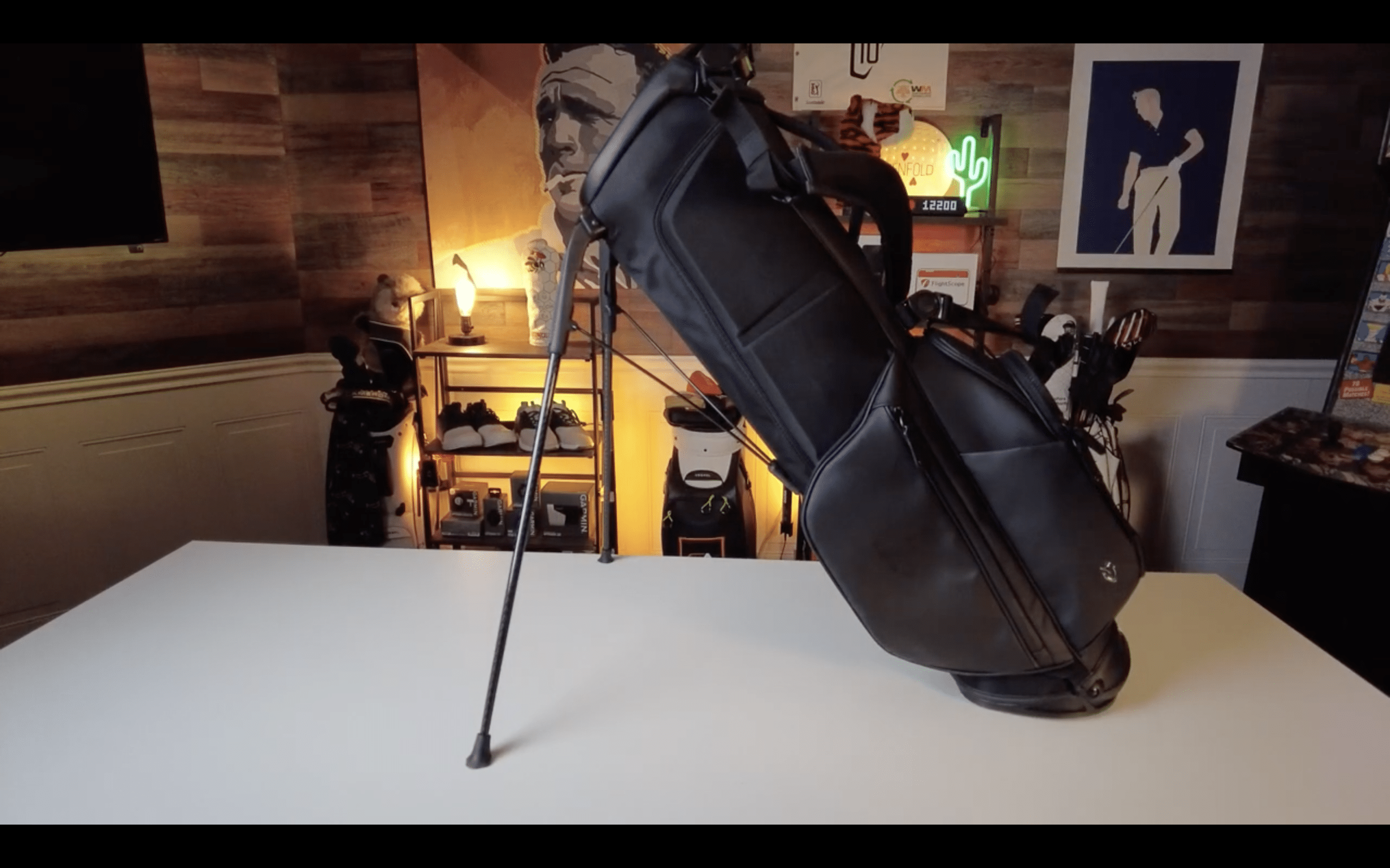 Black golf bag standing on white table