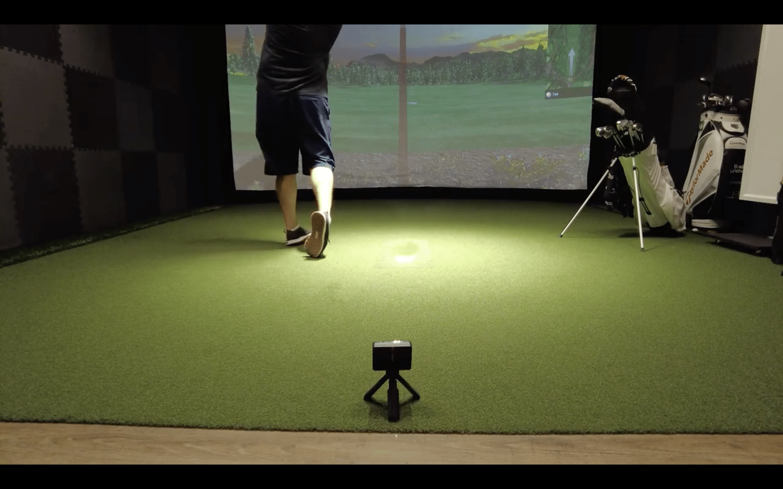 Person playing golf on indoor simulator setup