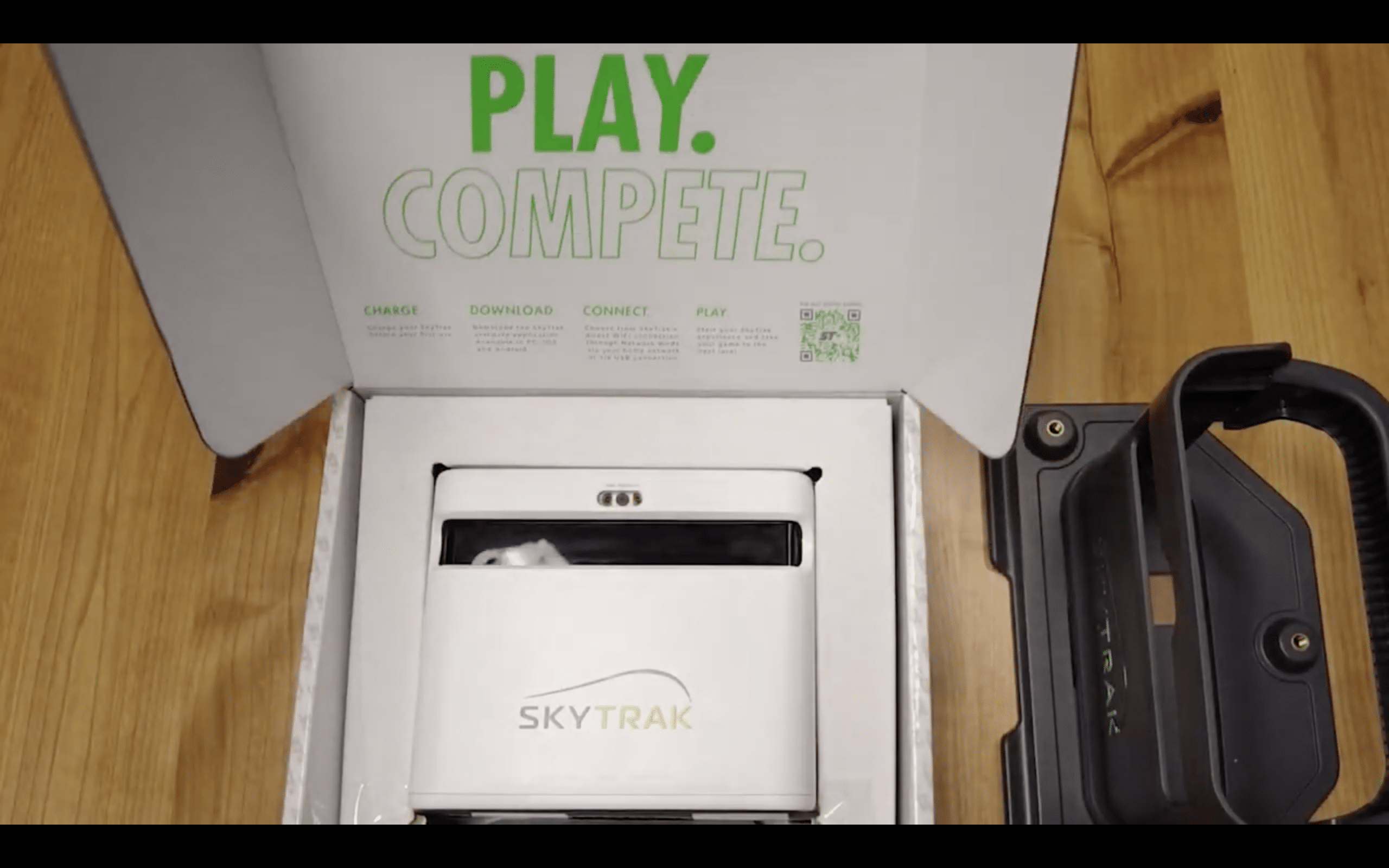 SkyTrak golf launch monitor unboxing on wooden table