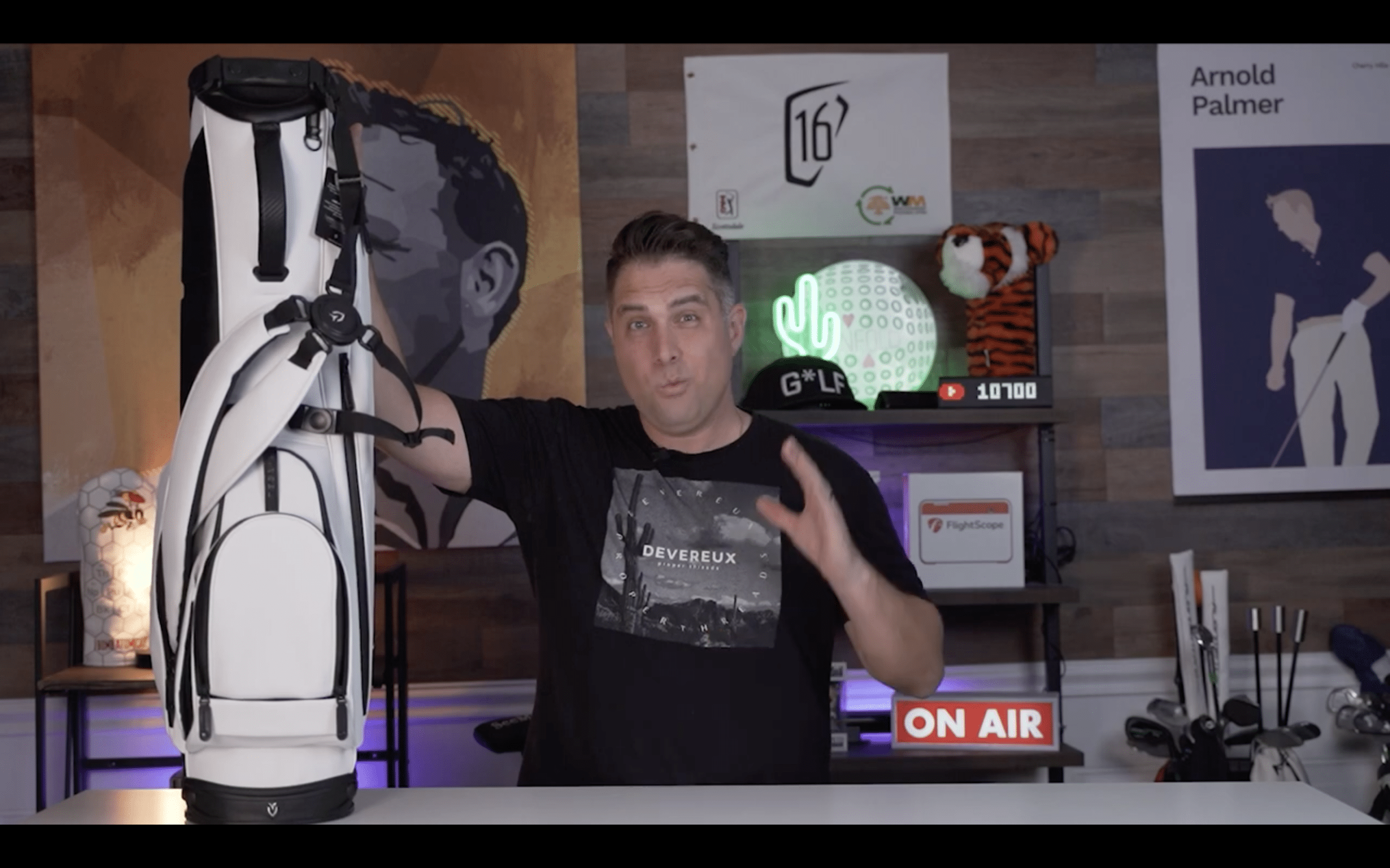 Man presenting a white golf bag indoors