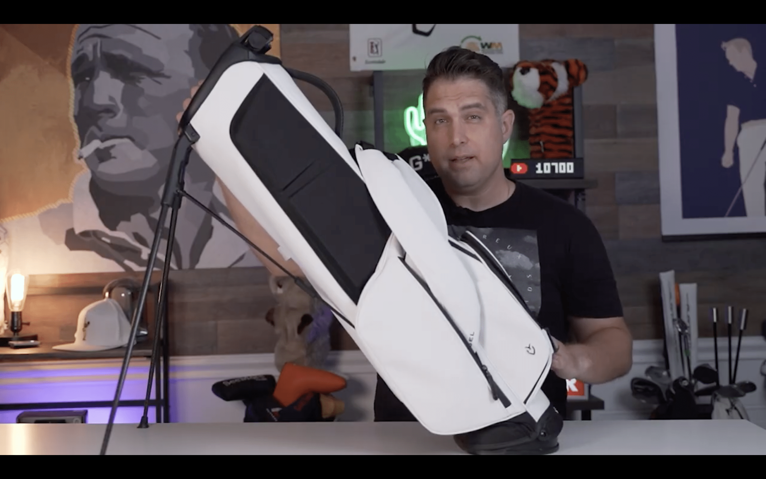 Person holding a white golf bag indoors