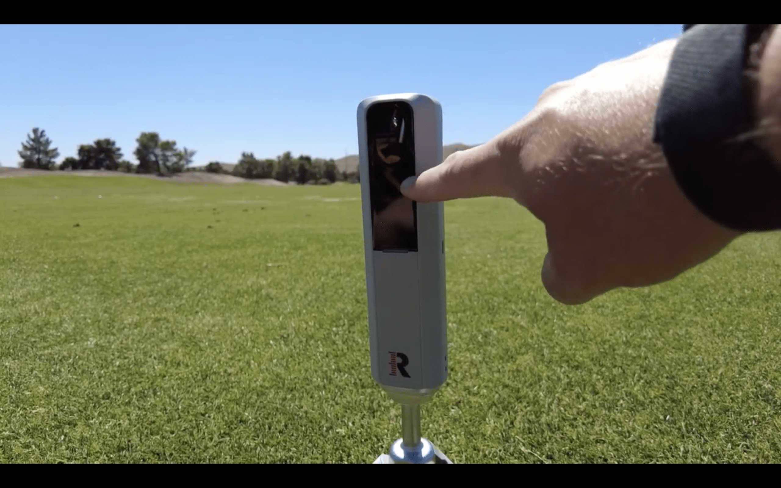 Person using golf launch monitor outdoors