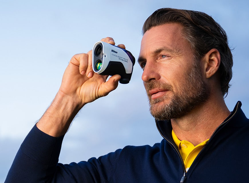 Man using Nikon golf rangefinder outdoors