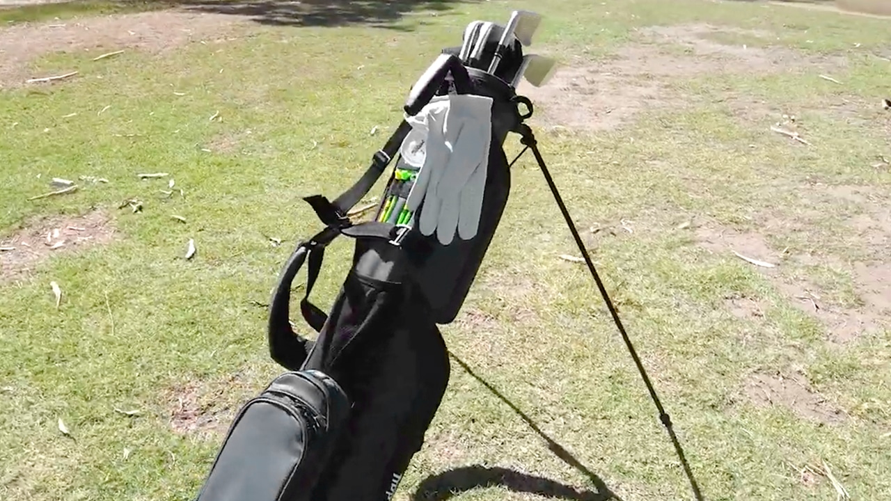 Golf bag with clubs on grassy course