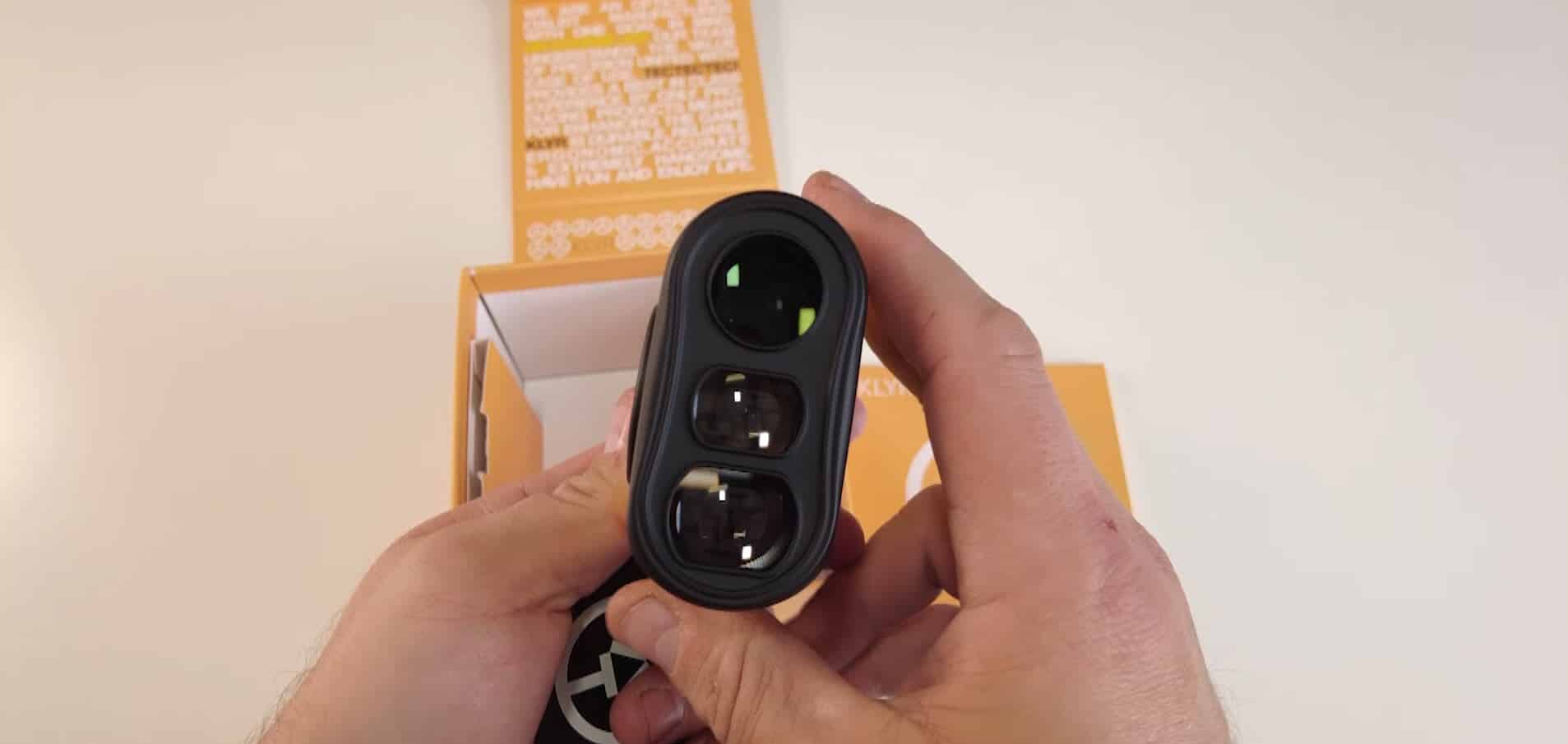 Person holding black rangefinder device