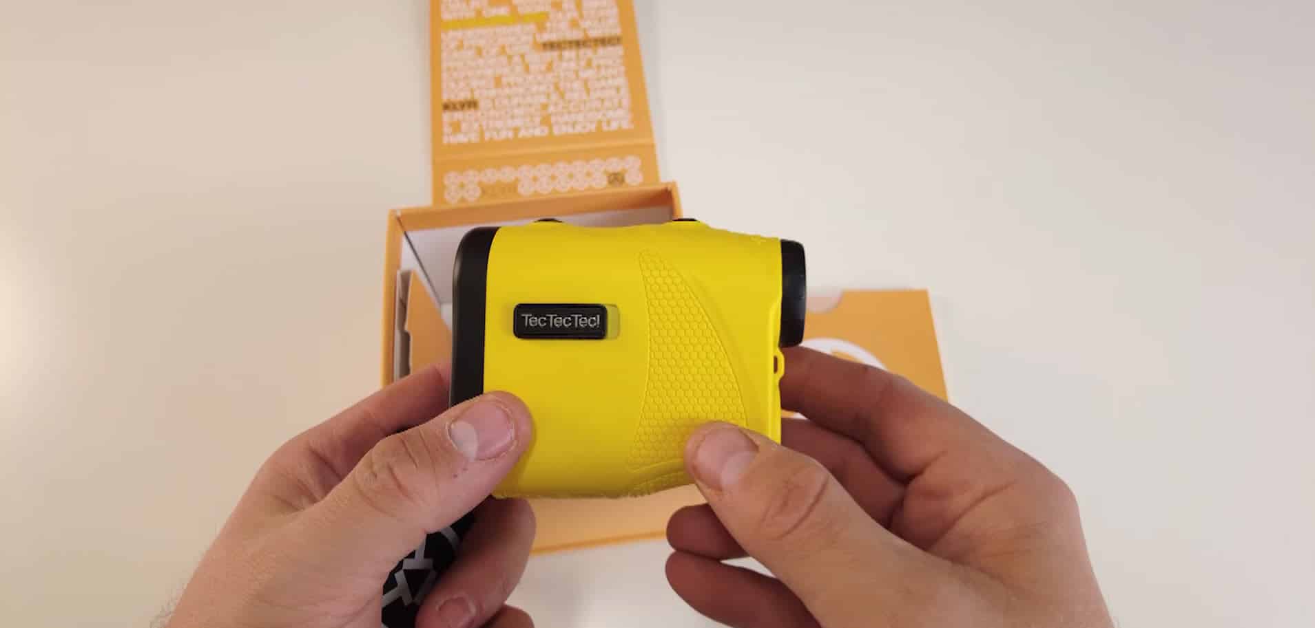 Person holding yellow TecTecTec rangefinder