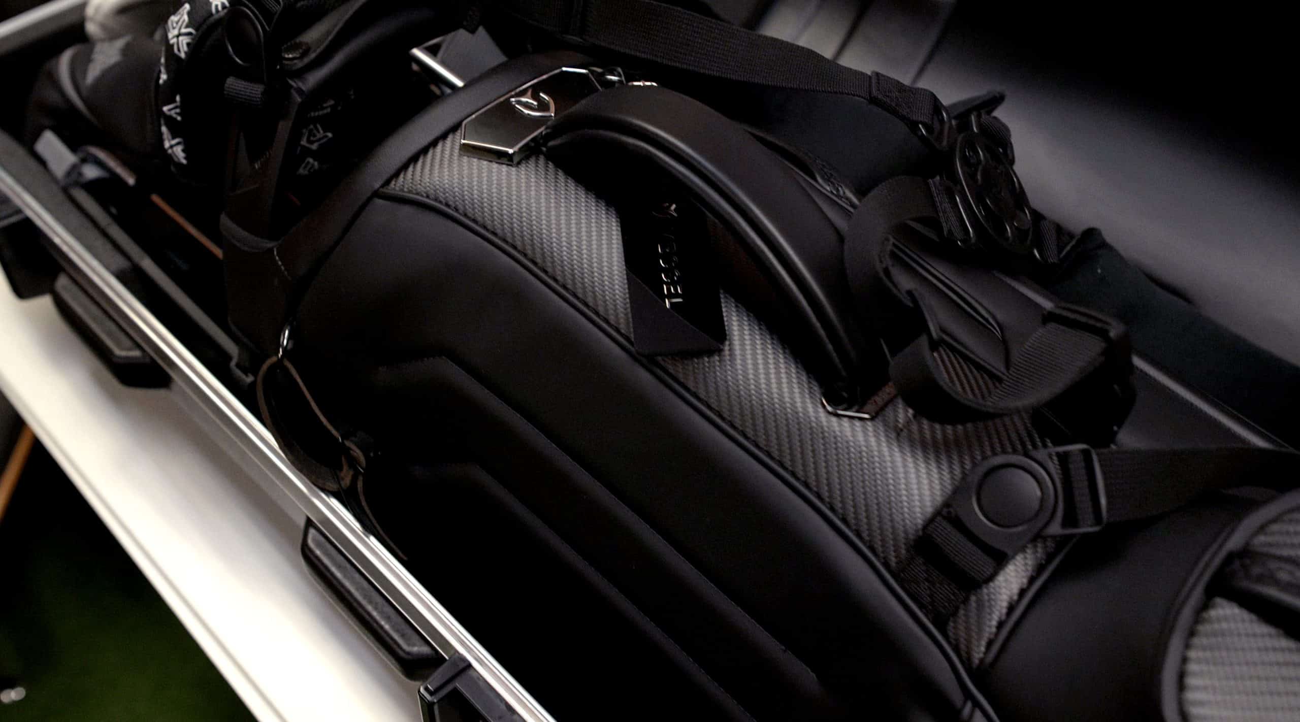 Black carbon fiber golf bag in car trunk