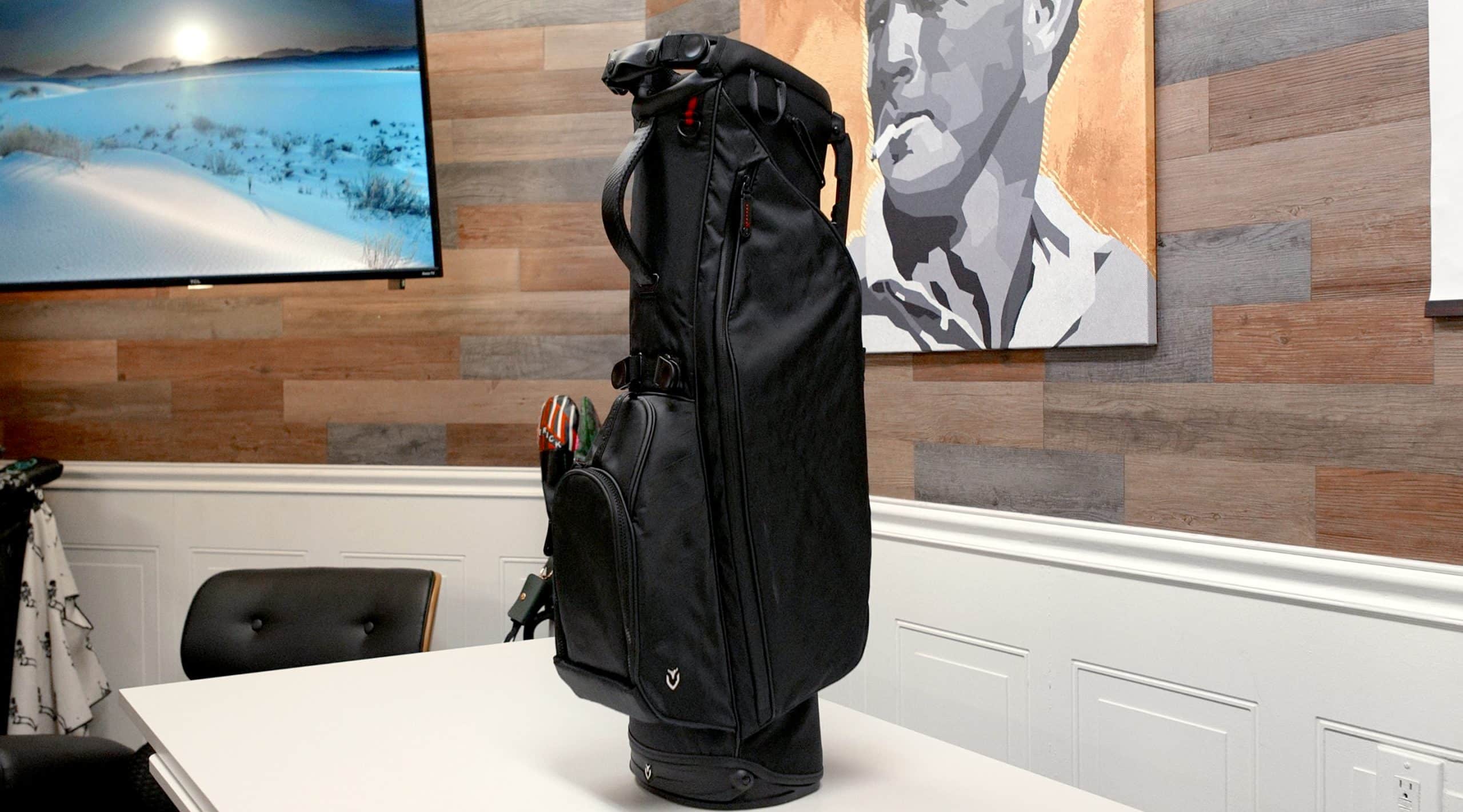 Black golf bag on white table indoors