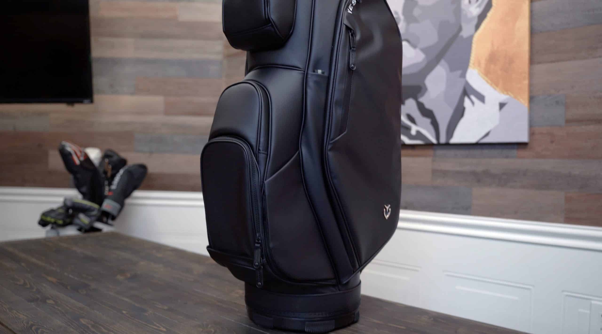 Black golf bag on wooden table indoors