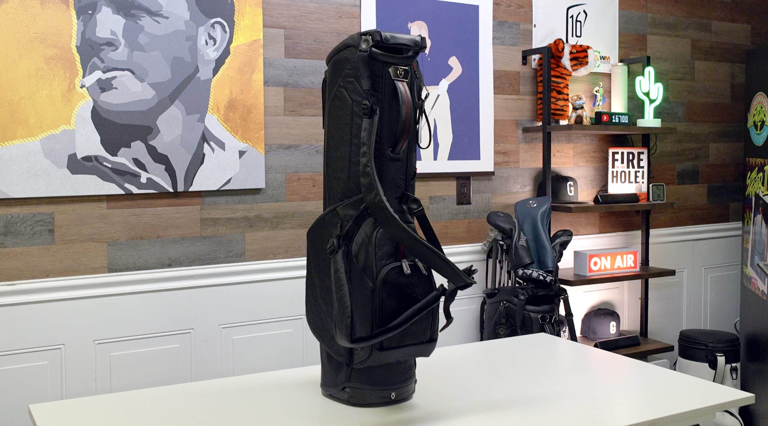 Black golf bag on white table in studio