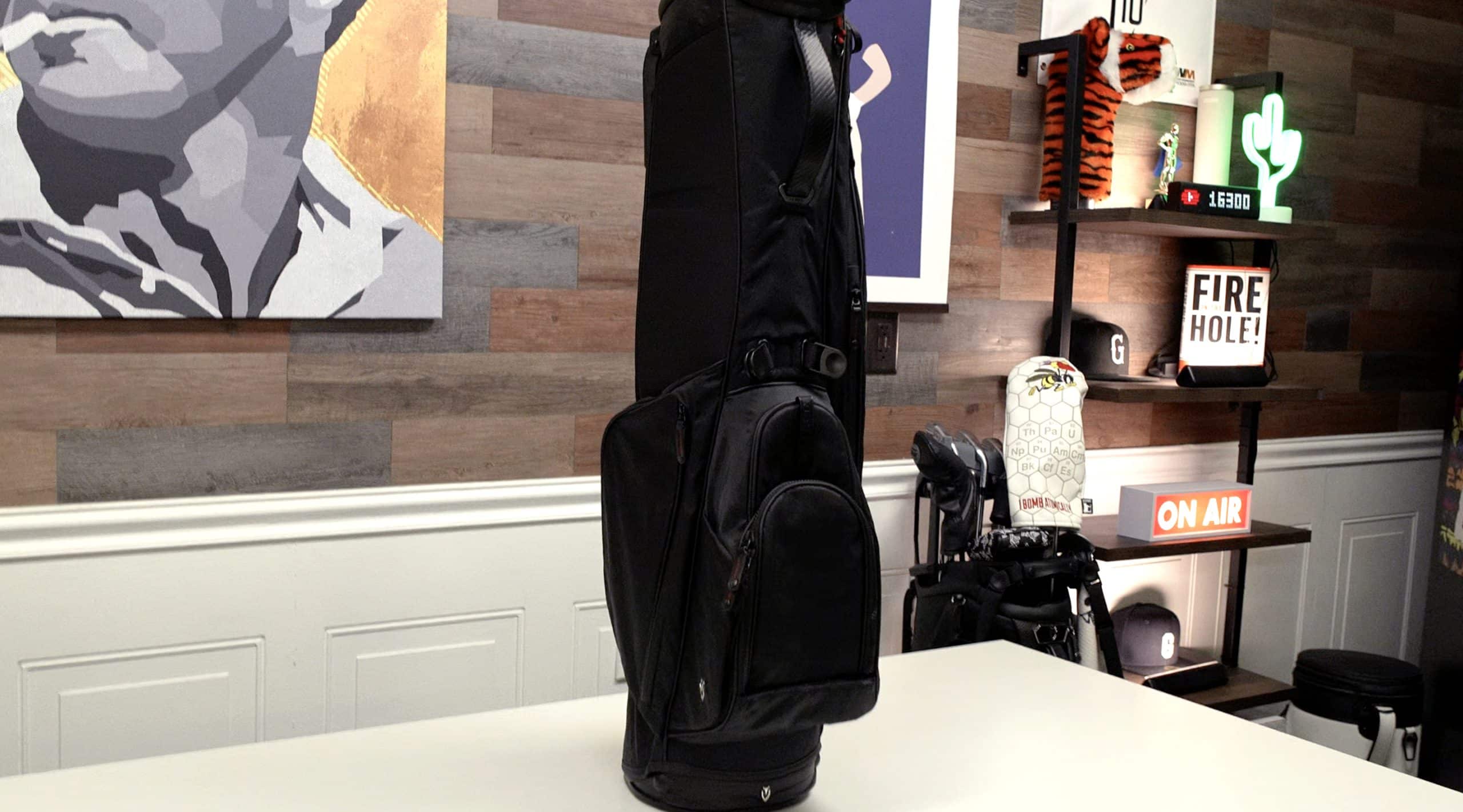 Black golf bag on white table in studio