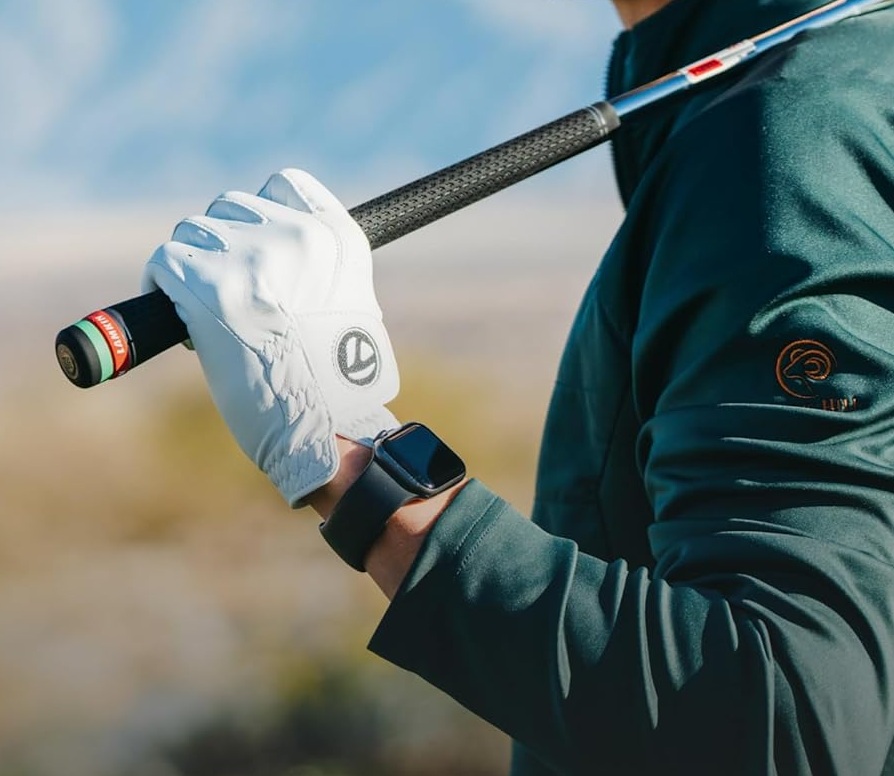 Golfer holding club wearing glove and smartwatch