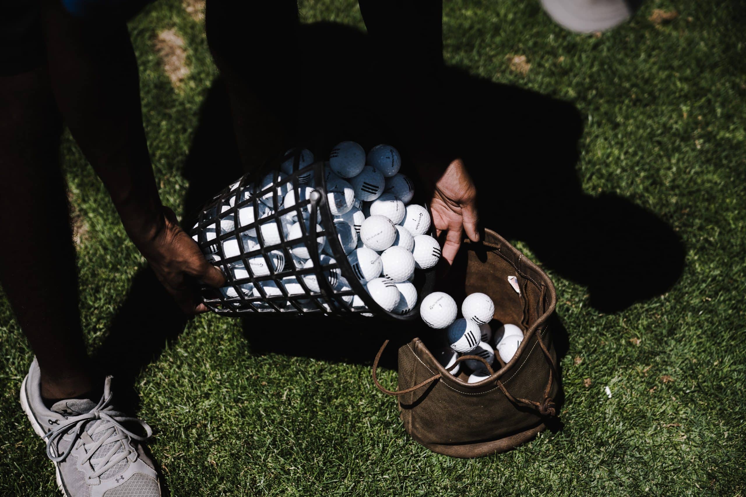 Person pouring golf balls into a bag