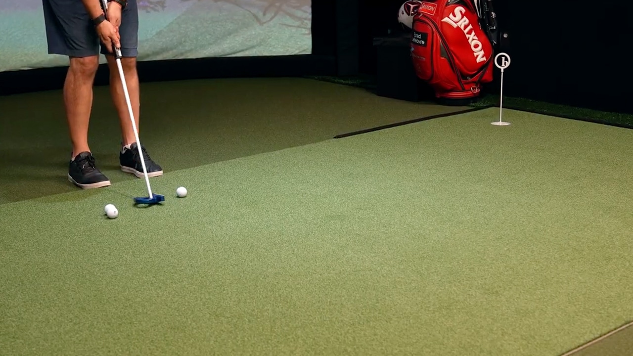 Golfer practicing putting on indoor green