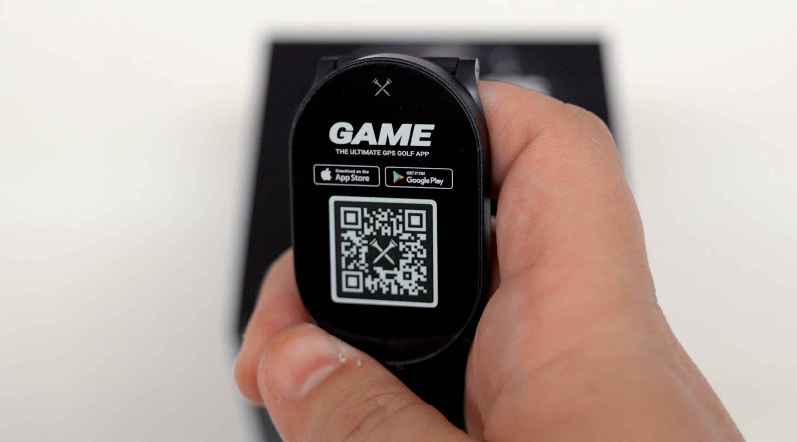 Hand holding smartwatch showing golf app QR code
