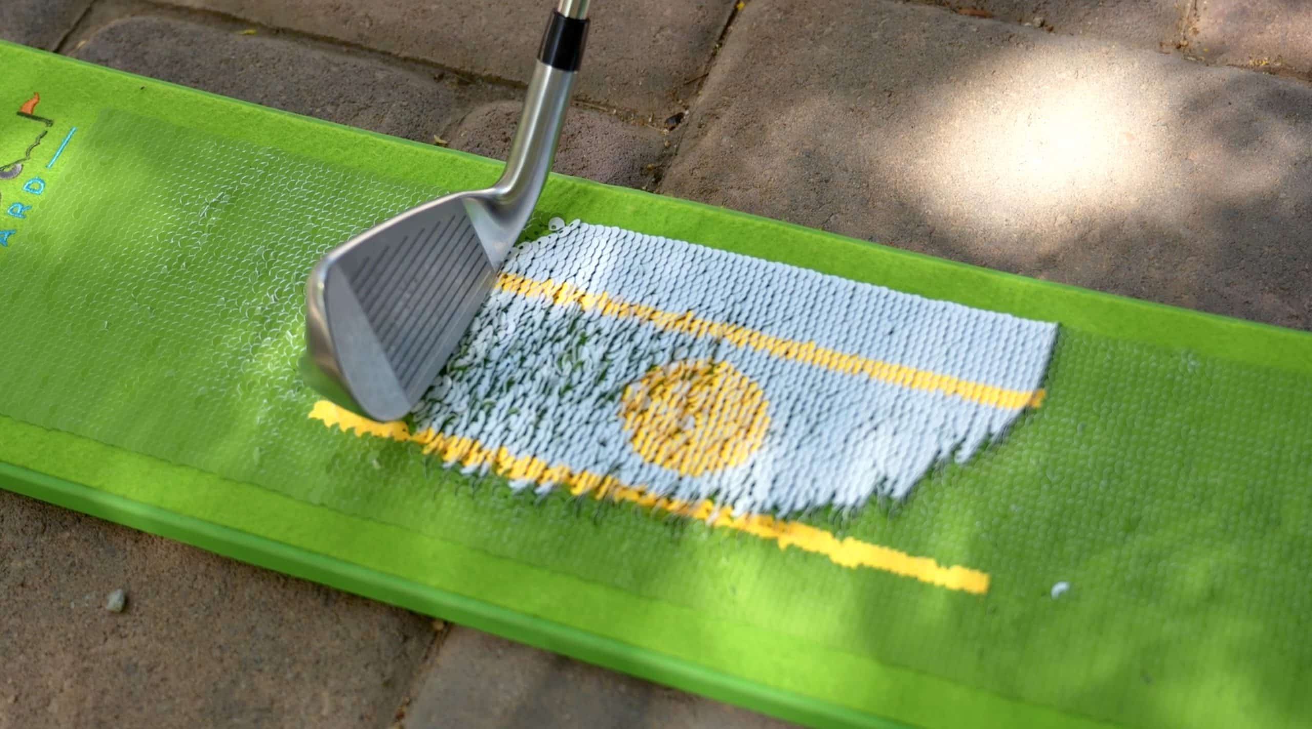 Golf club hitting practice mat outdoors