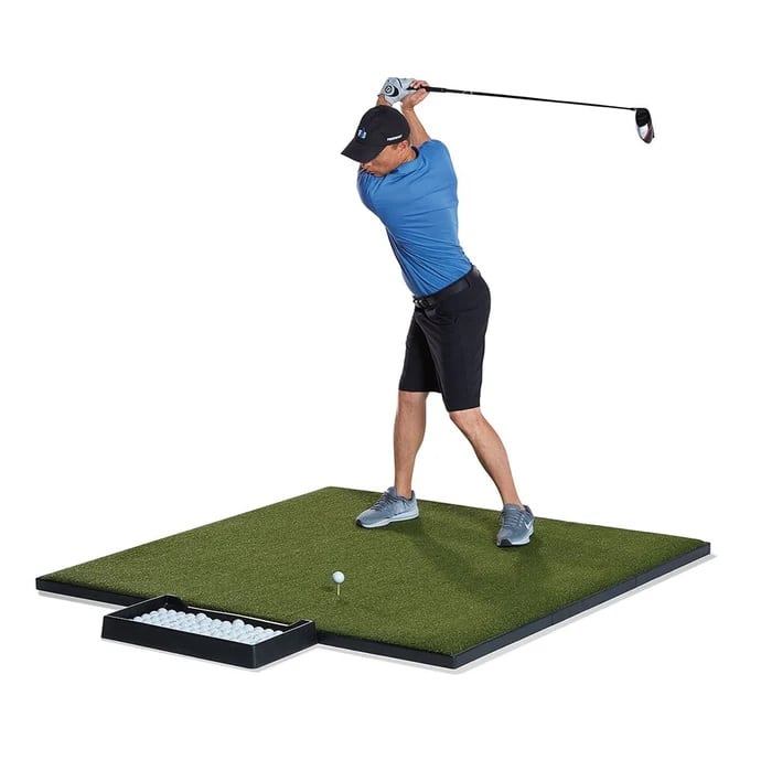 Golfer swinging club on practice mat