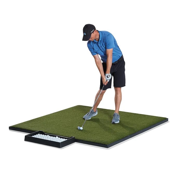 Golfer practicing swing on artificial turf mat
