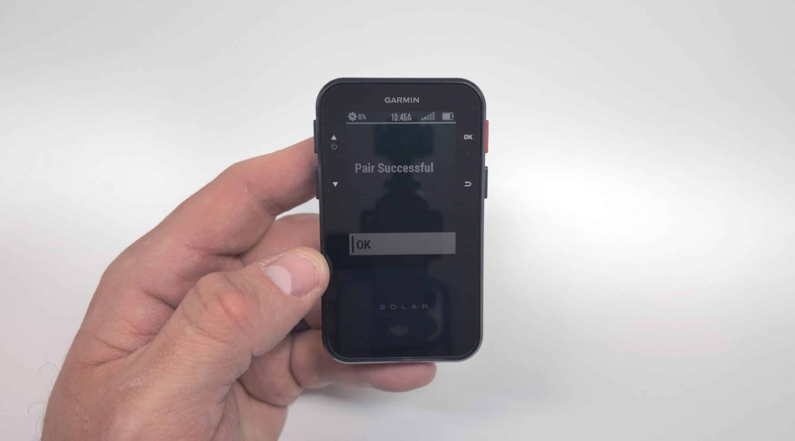 Hand holding Garmin device showing pairing successful