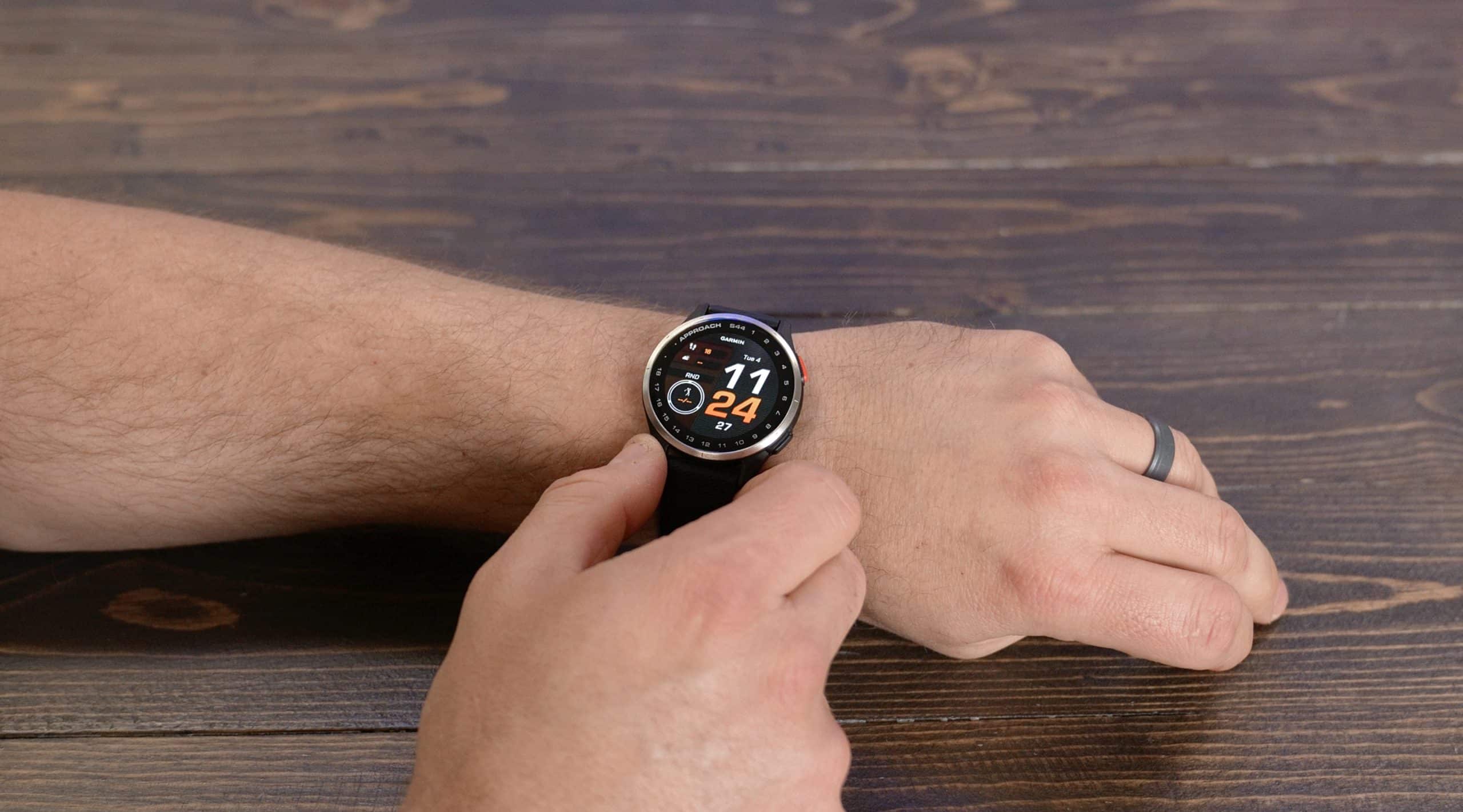 Person wearing smartwatch on wooden table