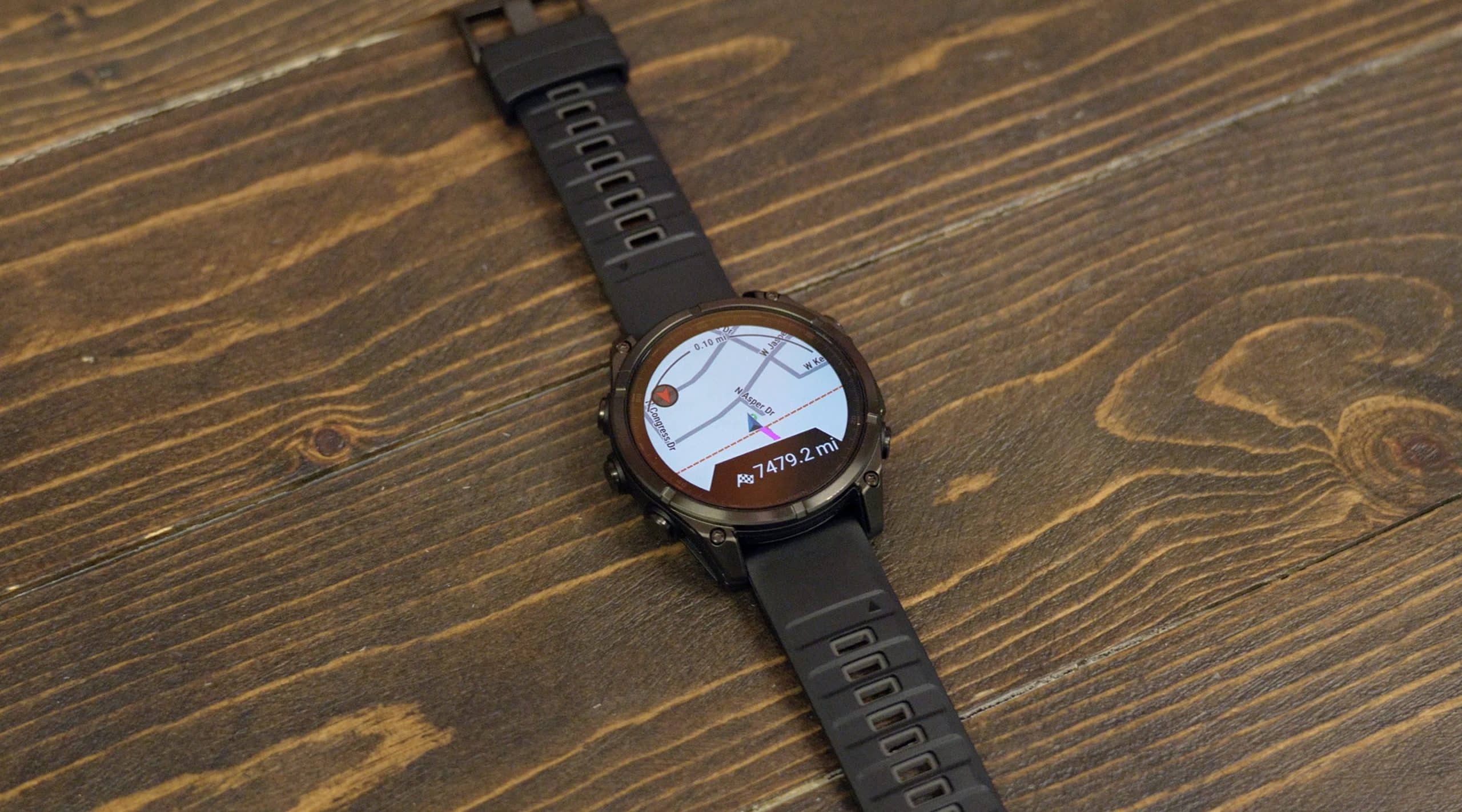 Smartwatch displaying GPS navigation on wooden surface