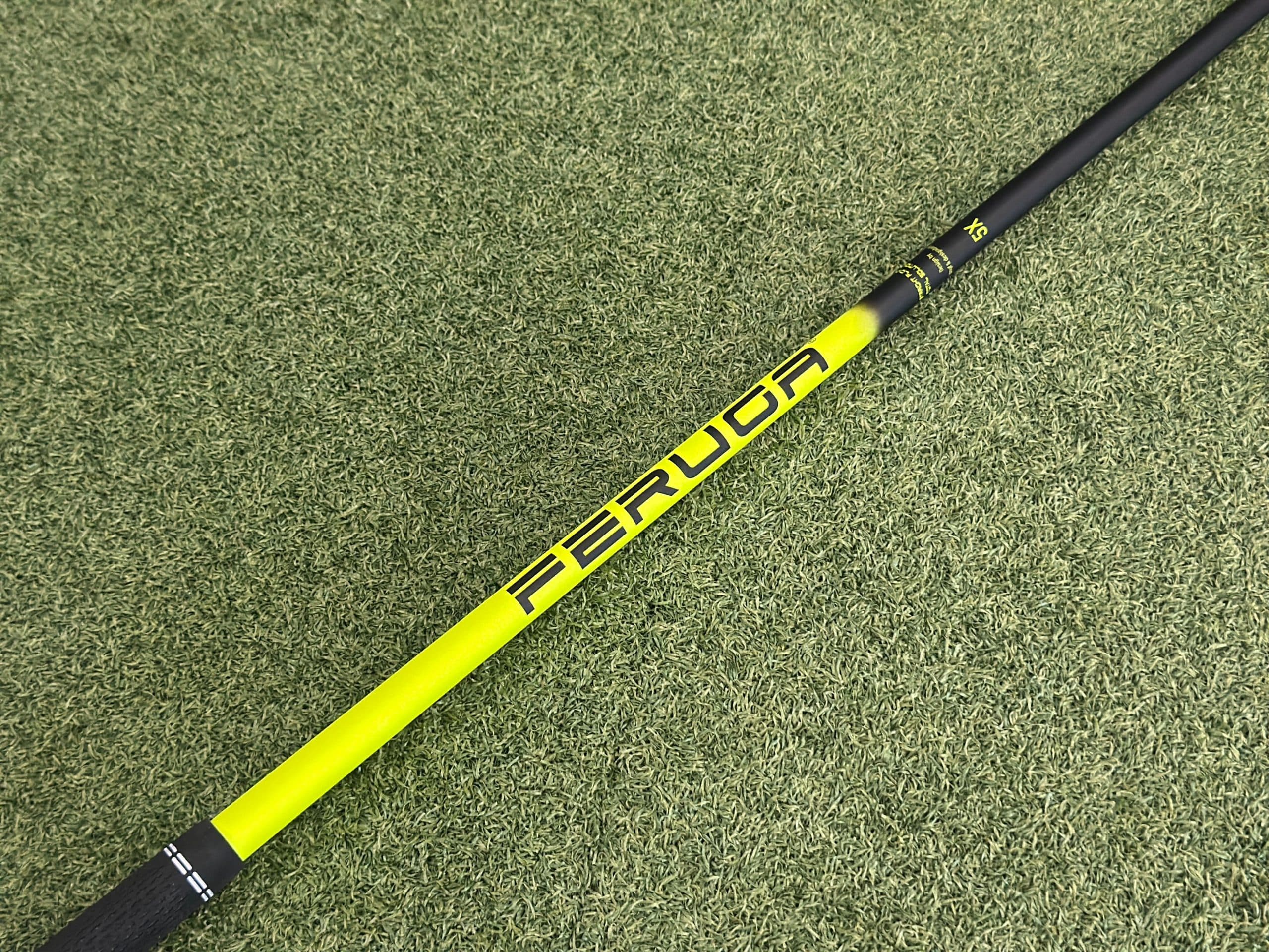 Yellow and black golf club shaft on turf
