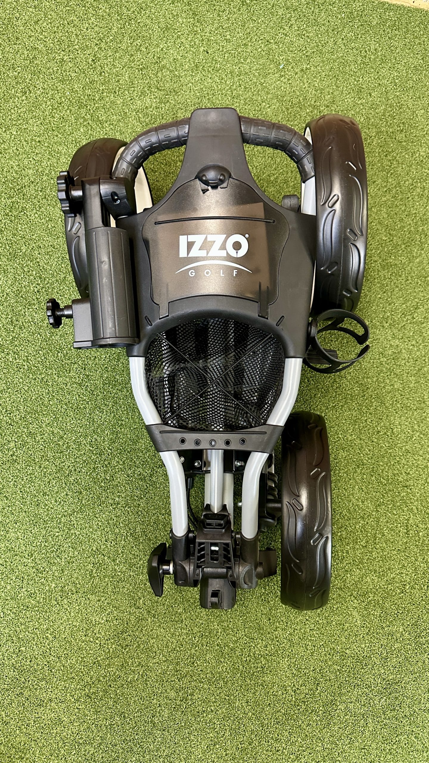 Folded Izzo golf push cart on turf