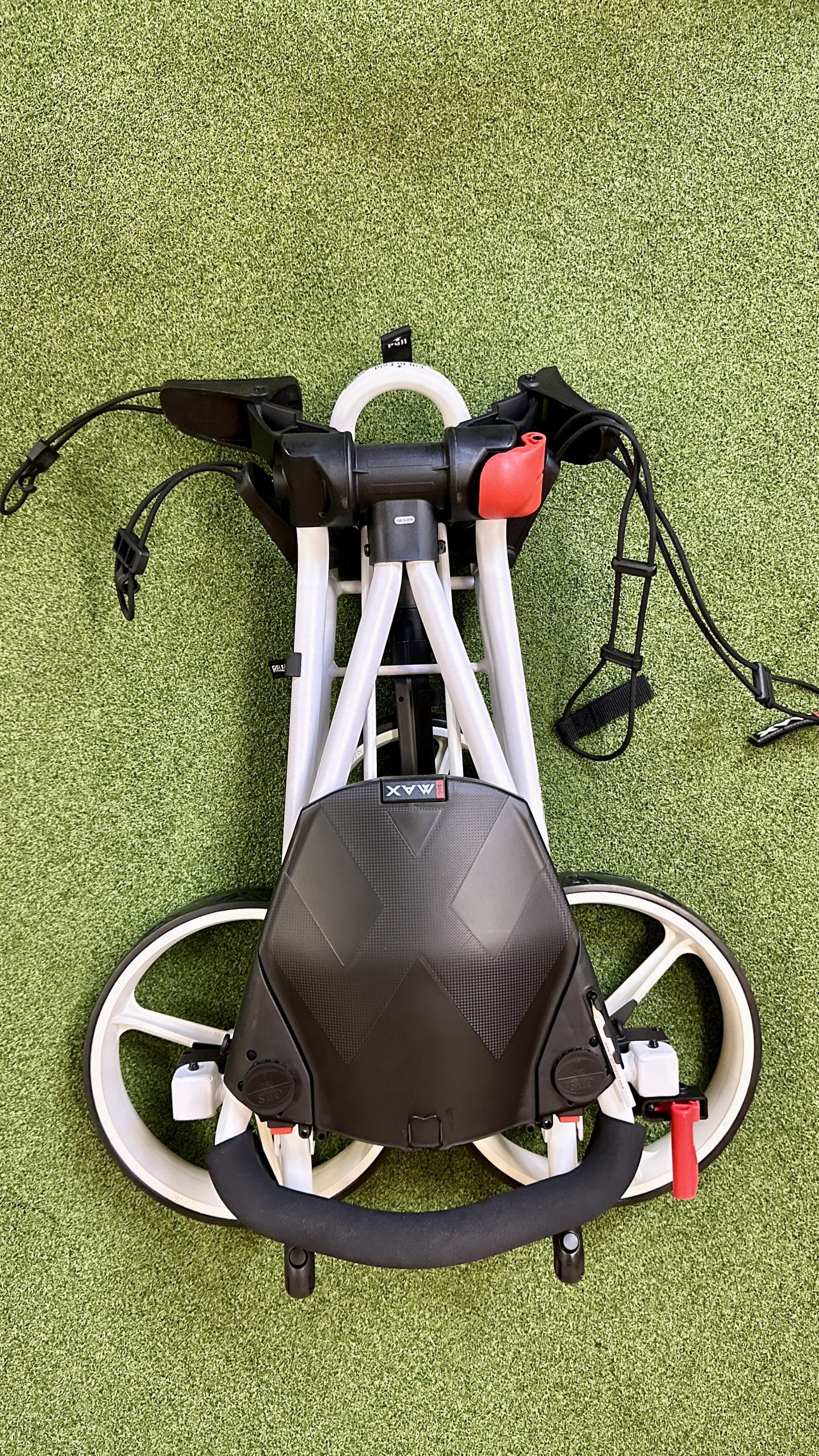 Folded golf push cart on green turf