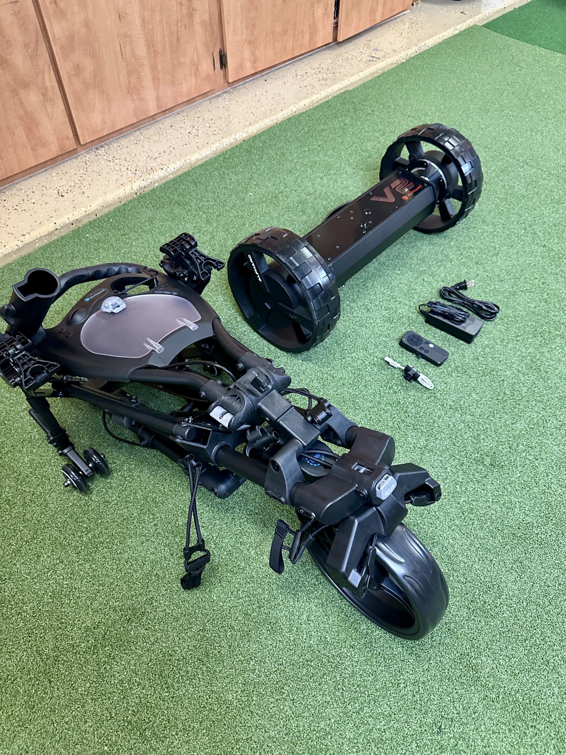 Foldable electric golf caddy with accessories on turf