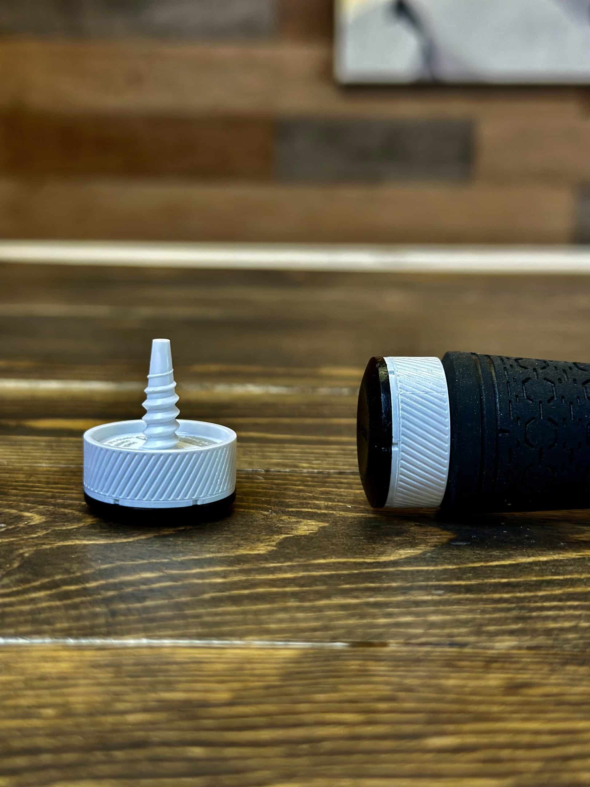 Black handle with white screw cap on table
