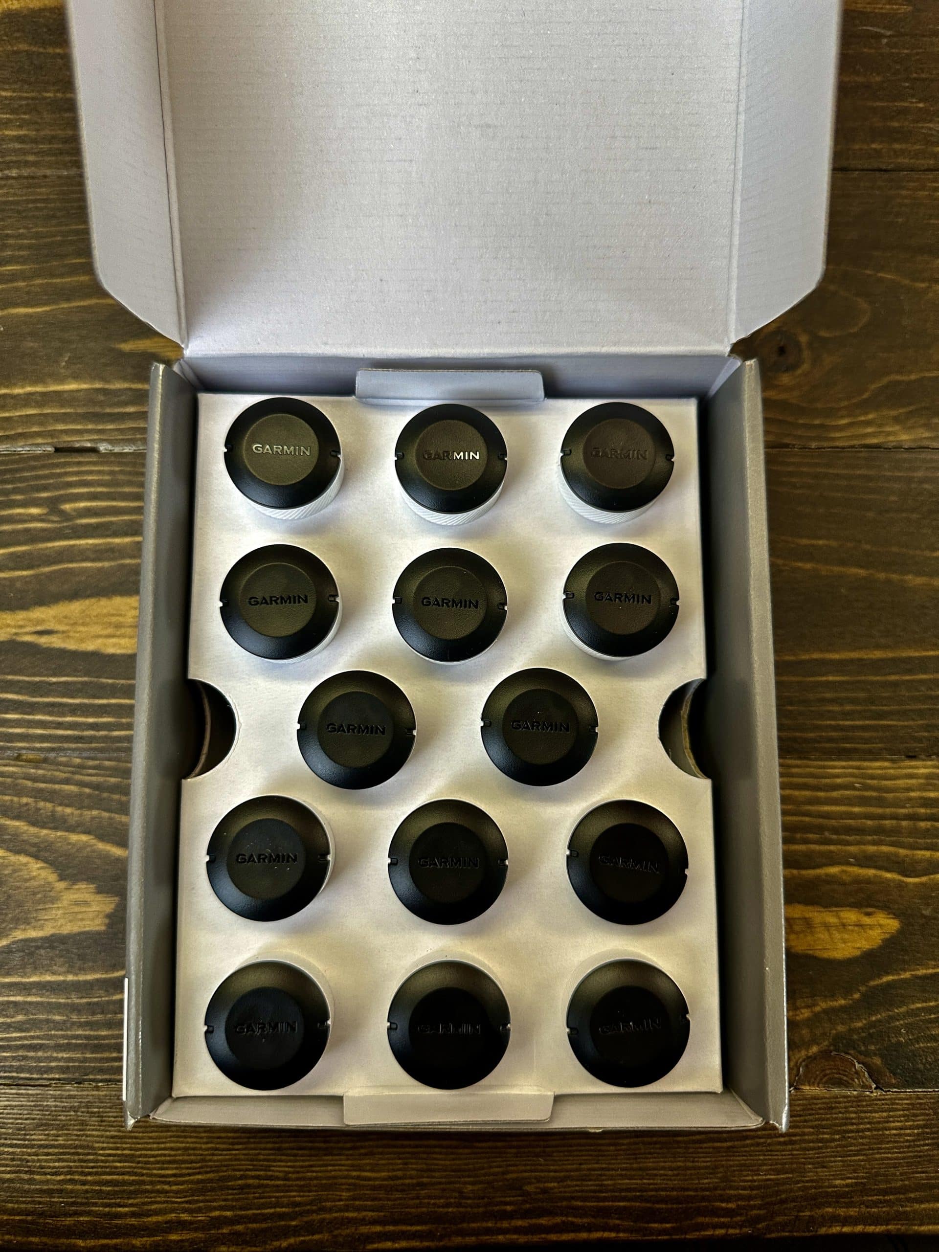 Box of Garmin golf club sensors neatly arranged.