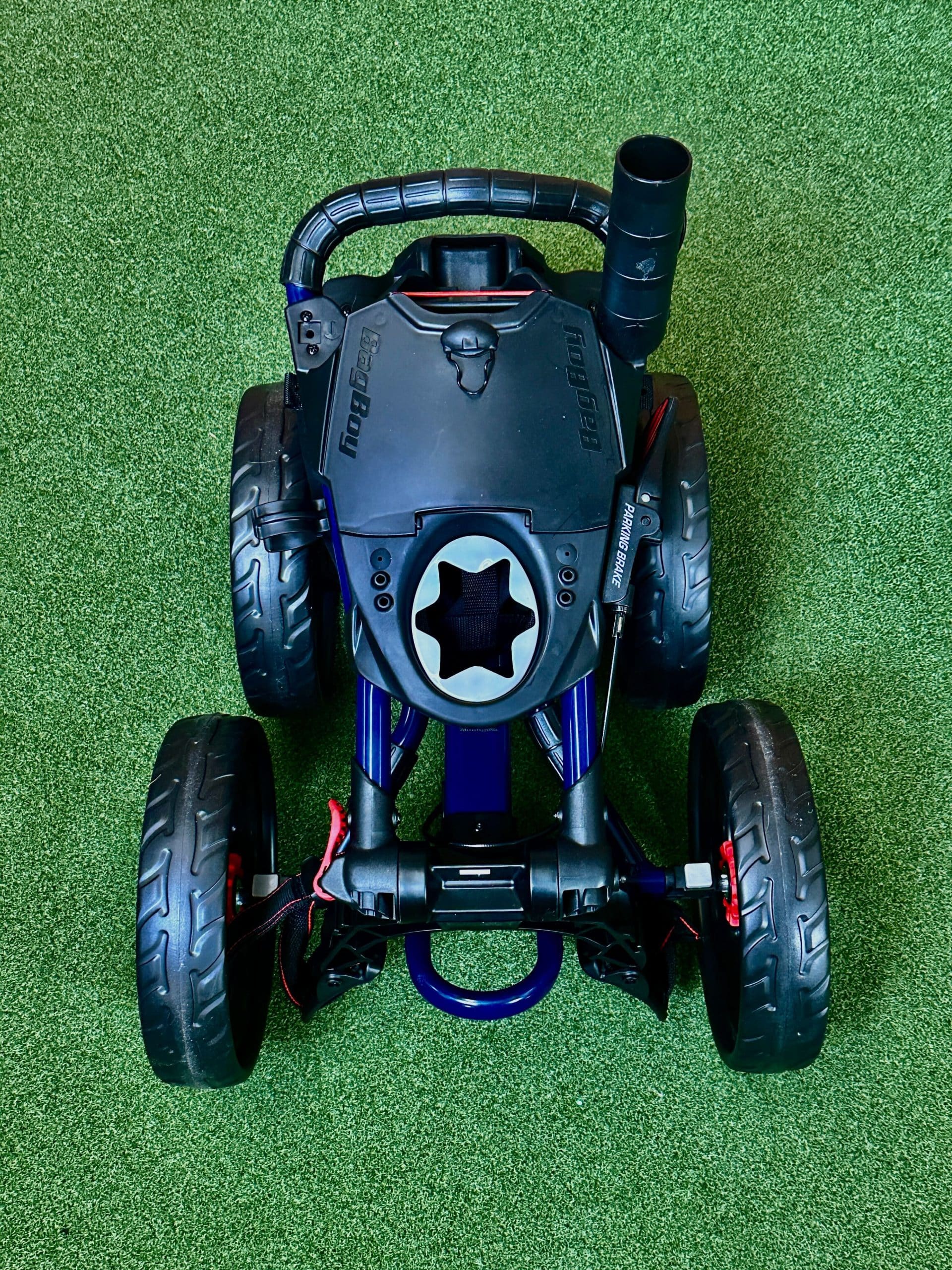 Folded golf push cart on green turf