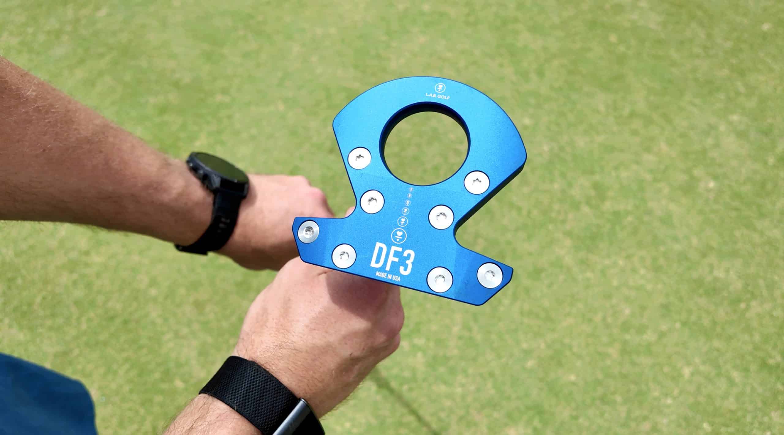 Person holding blue DF3 golf putter on green