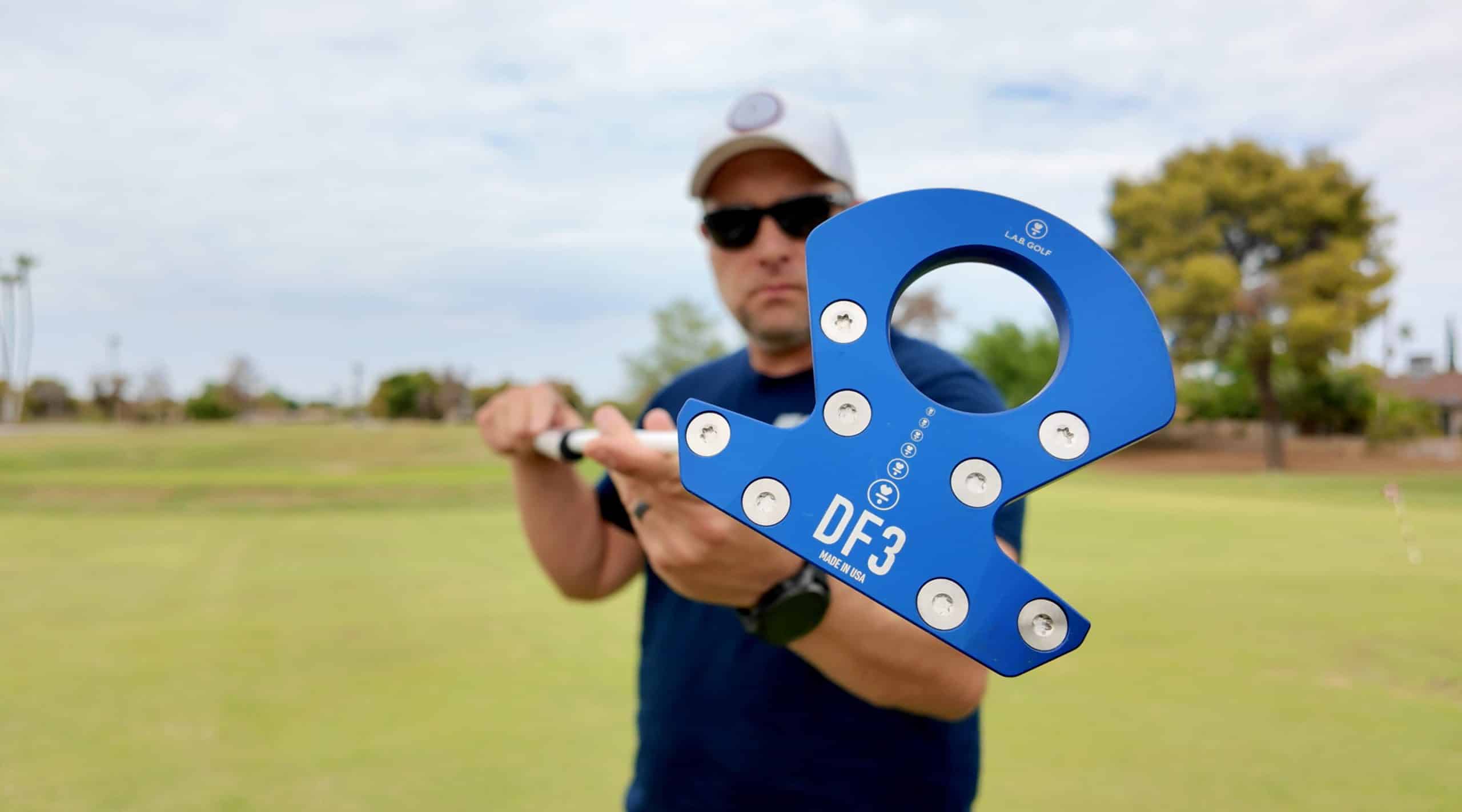 Golfer holding blue DF3 putter on course