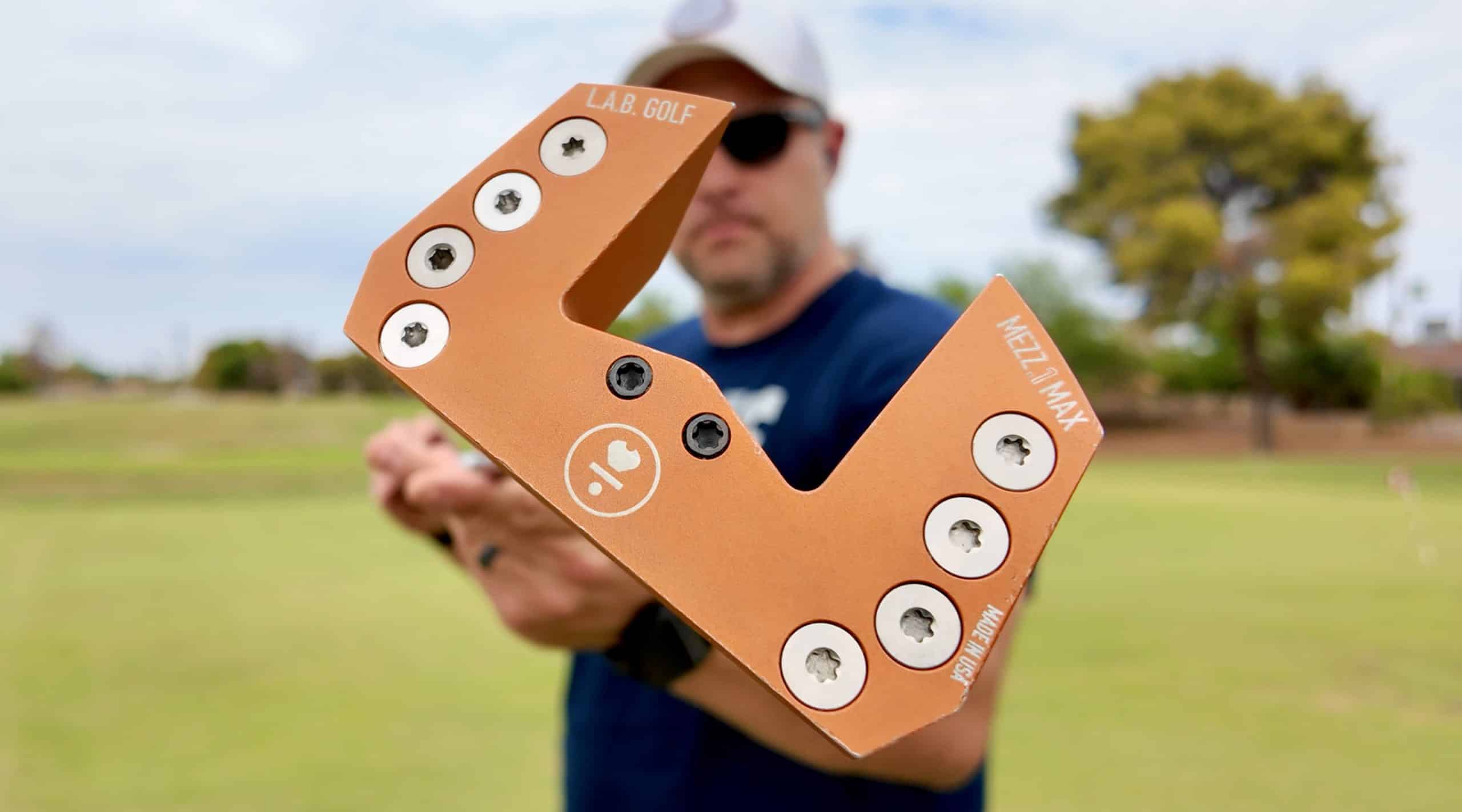 Golfer holding orange L.A.B. Golf Mezz.1 Max putter