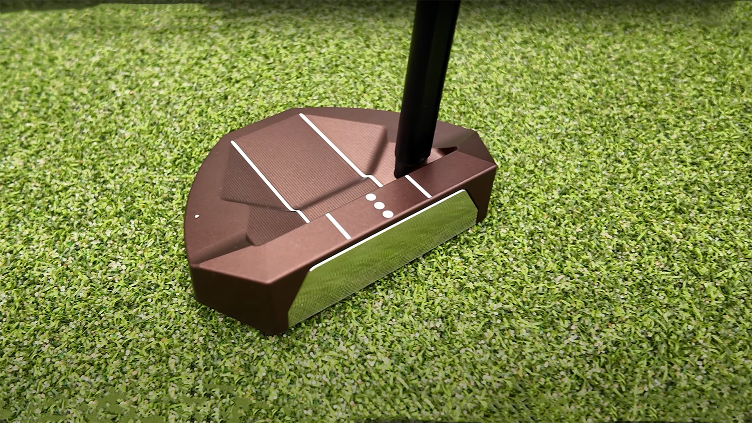 Golf putter resting on artificial grass surface