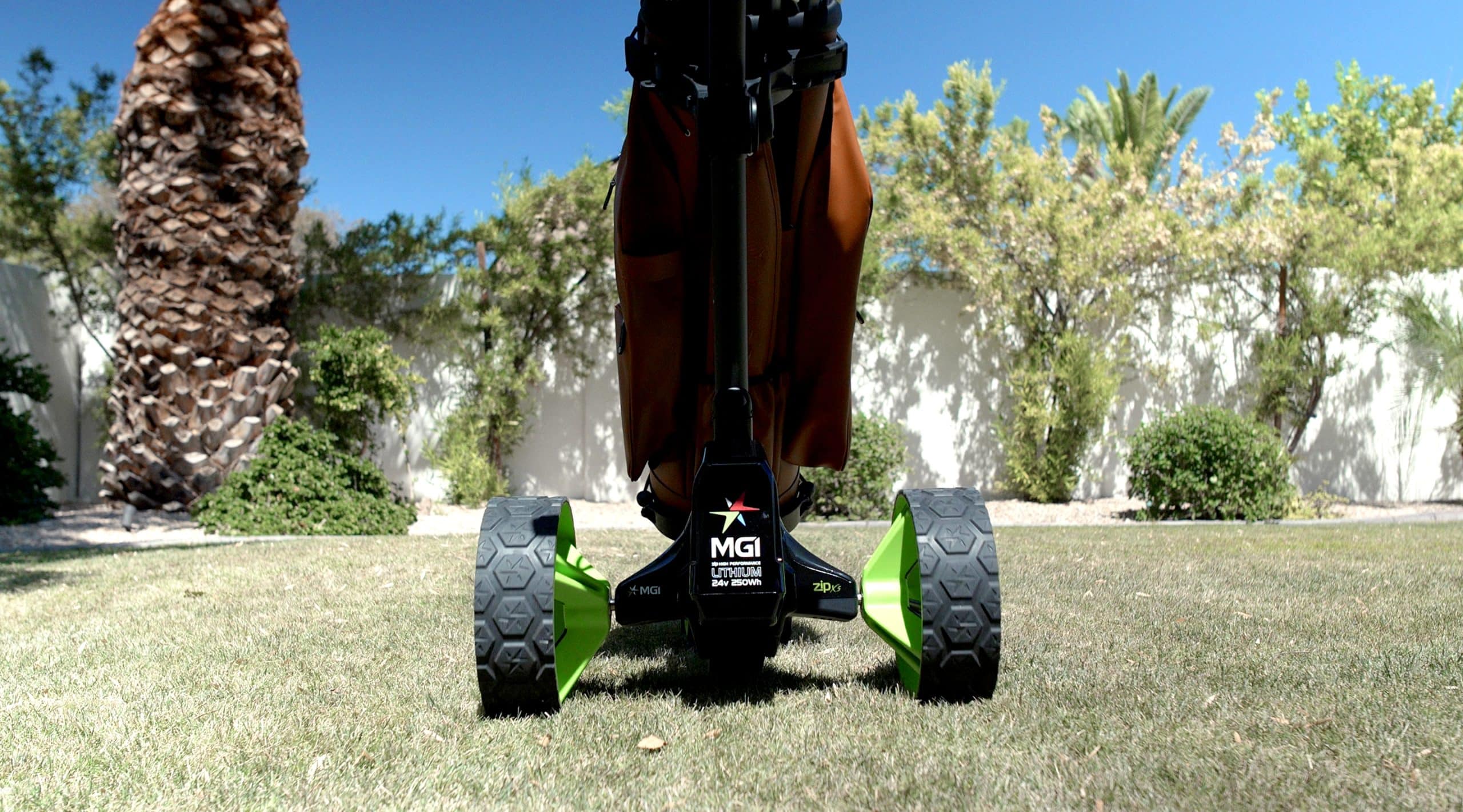 Electric golf push cart on grassy lawn